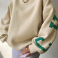 Oversized varsity sweatshirt with green letter graphic